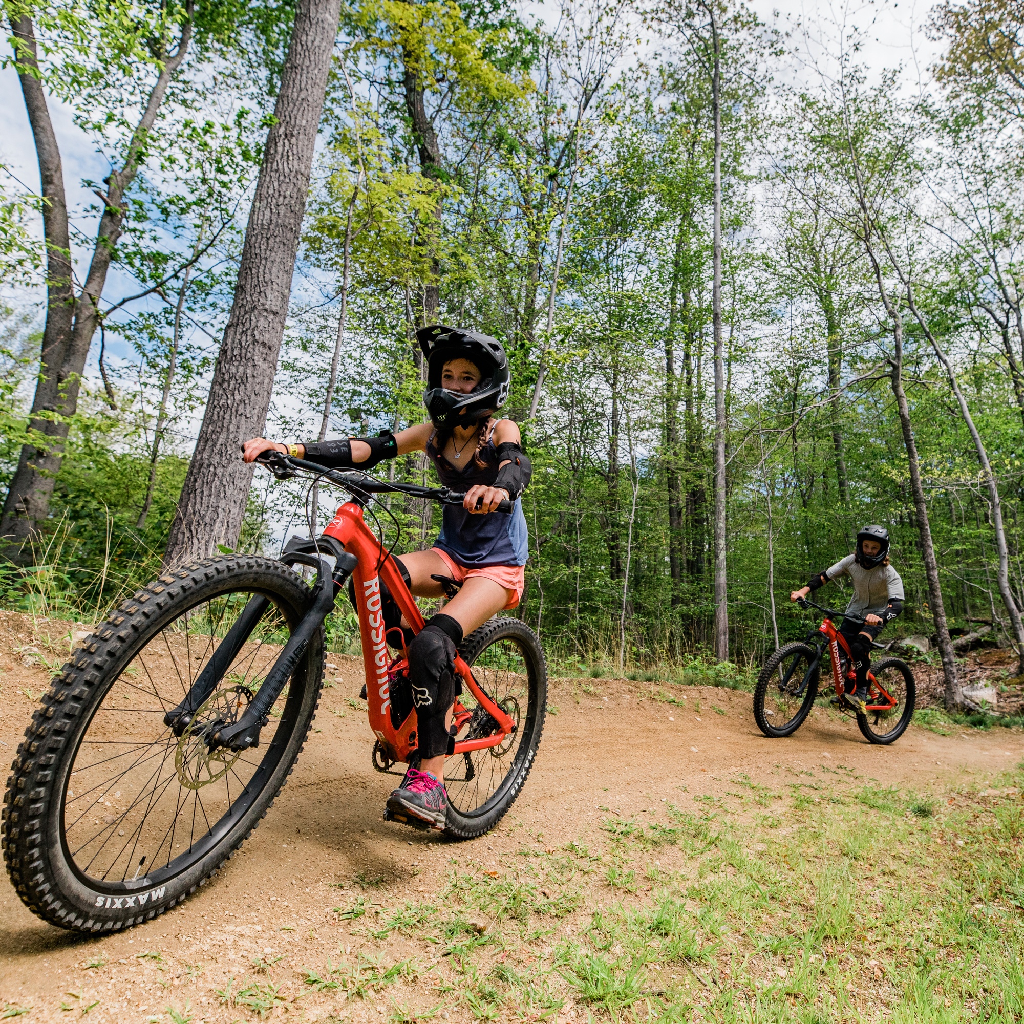 Family riding flow trail coming around curve