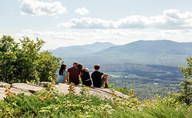 Family sitting on the rocks at the top of Cranmore