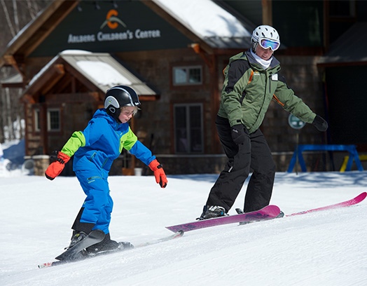 child and instructor skating uphill
