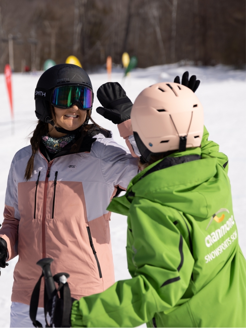 Skier and instructor giving high five