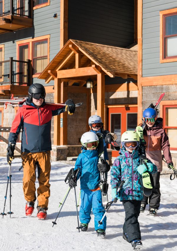 Family with Skis walking from Kearsarge Brook building